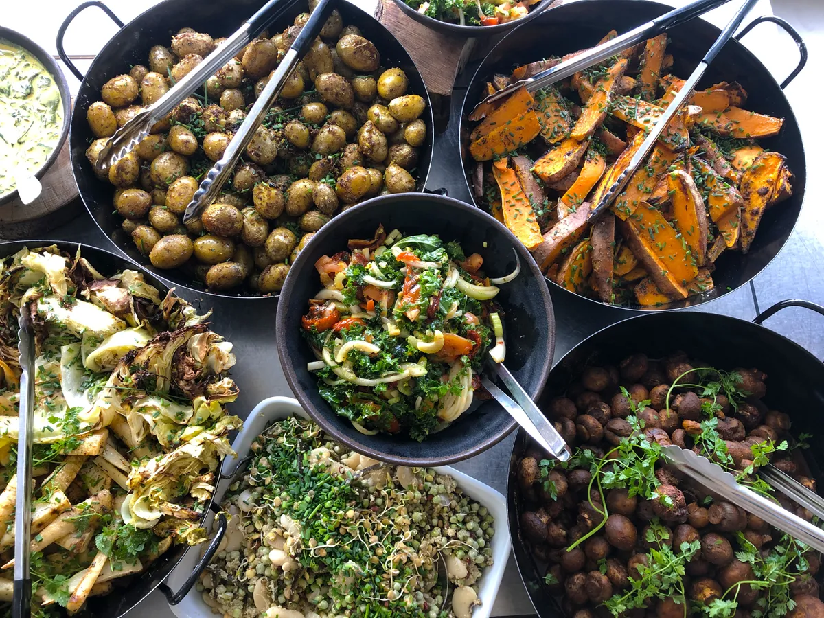 Varieret frokostbuffet med grøntsager, kartofler og salater til frokostordning på arbejdspladsen